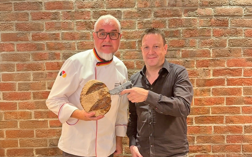Harald Pommer und Autor Josef Rauch mit Brot und Pistole in der Hand