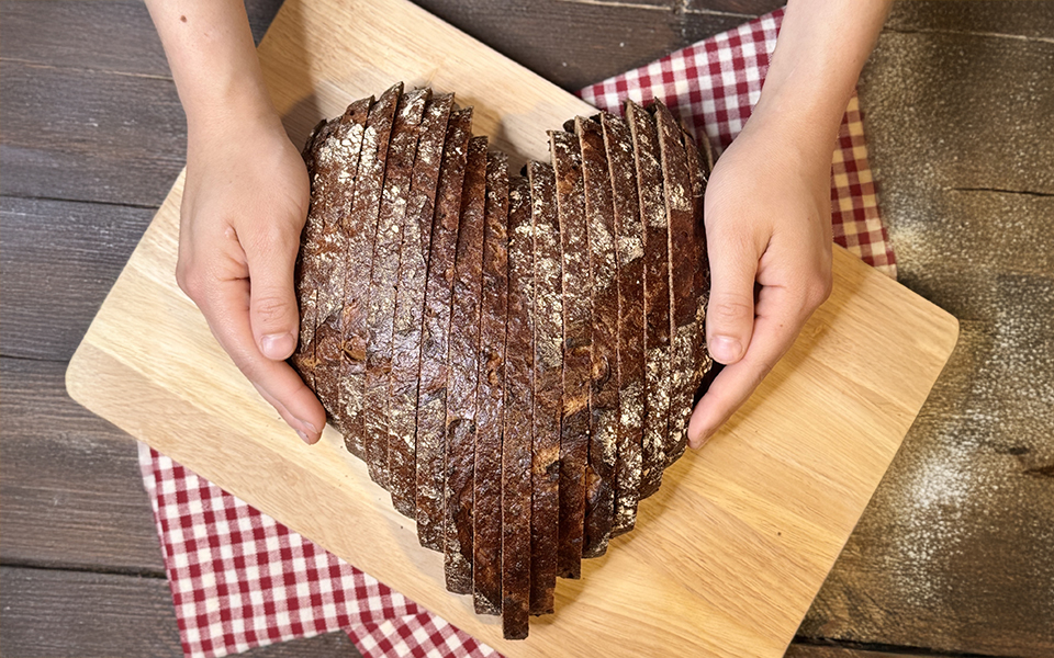 Hände in Herzform halten ein Brötchen 