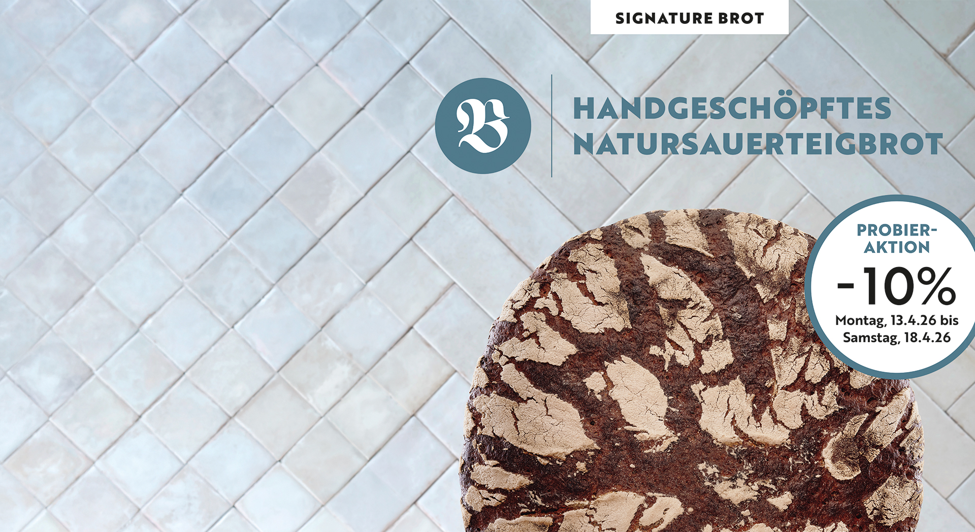 Ein Laib Handgeschöpftes Natursauerteigbrot vor einem hellblauen Fliesenhintergrund