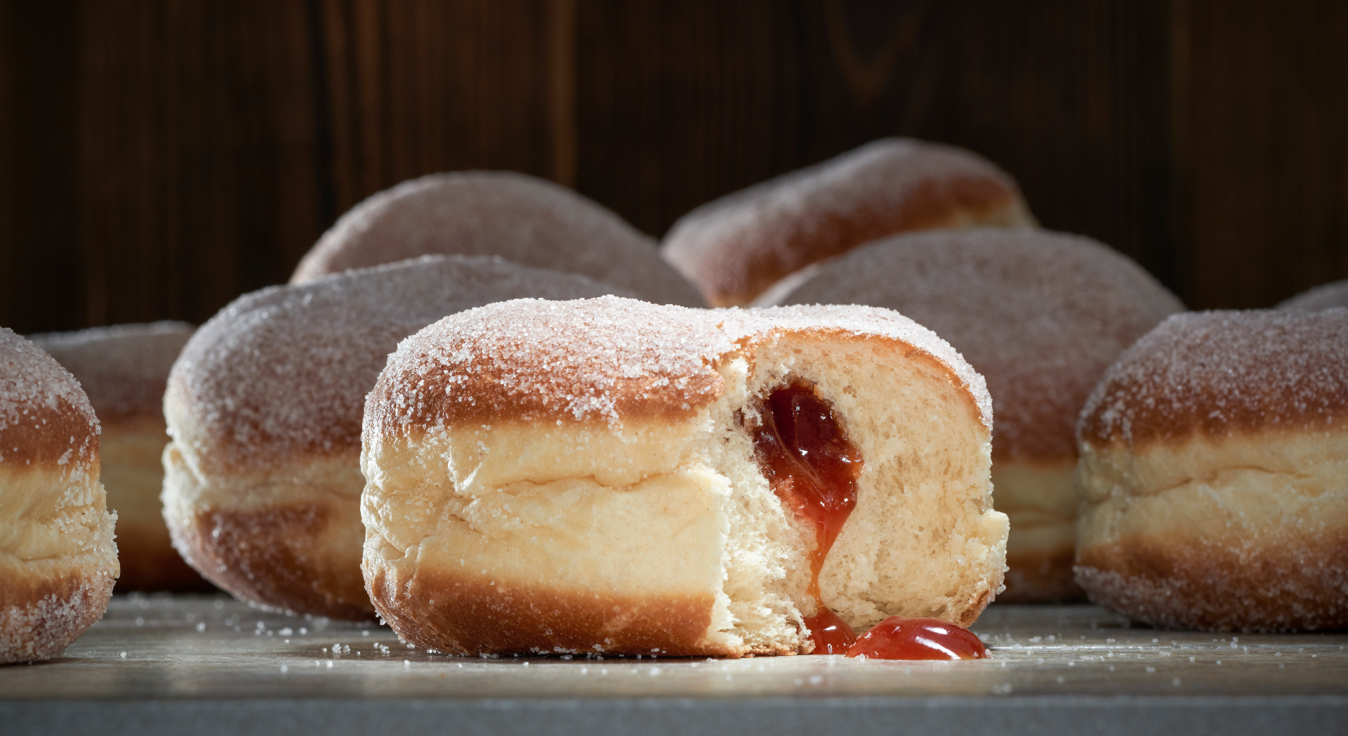 Mehrere Hiffenmarkkrapfen mit Kristallzucker, im Vordergrund ein angebissener Krapfen, aus dem HIffenmark läuft