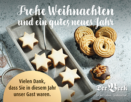 Zwei Schalen mit Weihnachtsplätzchen auf Steinuntergrund mit abgedruckten Weihnachtswünschen oberhalb