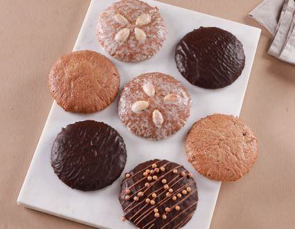 Einzelne Lebkuchen in unterschiedlichen Sorten liegen auf einem weißen Marmorbrett